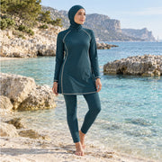 Femme portant un burkini couvrant bleu canard au bord de la mer – Maison Layina