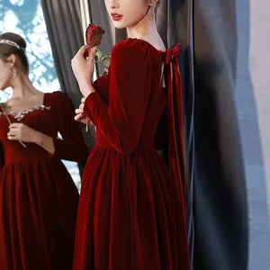 Dos de robe en velours bordeaux avec nœud et manches longues