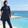 Femme portant un burkini UPF 50+ bleu marine près d’une piscine – Maison Layina