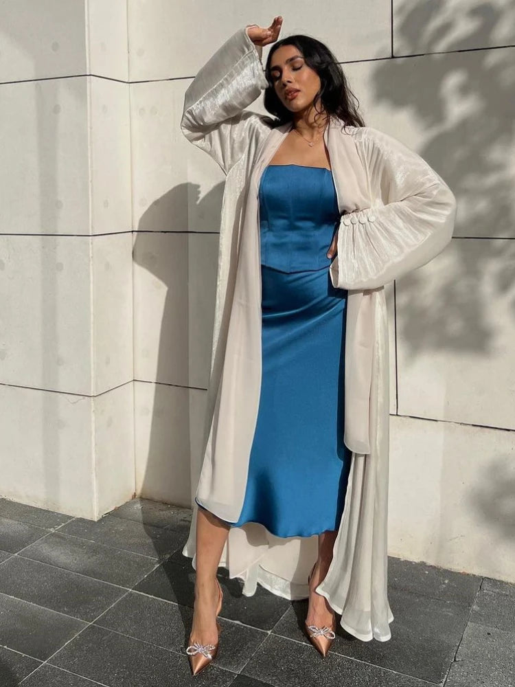 Abaya kimono satinée abricot ouverte sur une tenue bleue