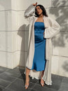 Abaya kimono satinée abricot ouverte sur une tenue bleue