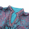 Détail du col orné de cristaux d'une abaya brocart turquoise et rose