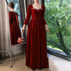 Robe longue en velours bordeaux près d'une fenêtre avec vue miroir
